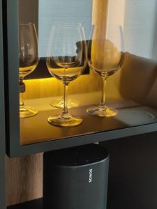 tres copas de vino sentadas en un estante en Haus Albatros EG - Exklusive Fewo für 4 Personen, en Dangast 12 fotos más
