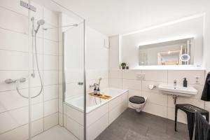 a white bathroom with a shower and a sink at LIVINGLike-Apartment - Central & Spacious with Balkony & Garage, Coffee - 103m2 in Pforzheim +19 photos