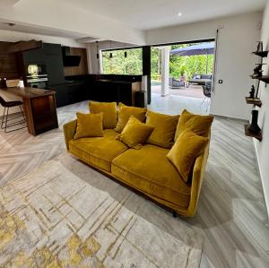 a yellow couch in a living room with a piano at Chaya Lodge in Petit-Bourg