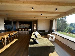 a living room with a couch and a bar at Villa Chalet Bledule-wellness & sauna in Roprachtice