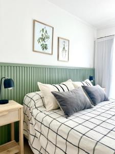 ein Bett in einem Schlafzimmer mit grünen und weißen Streifen in der Unterkunft Duplex zona calvario in Tandil