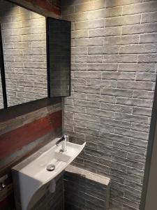 a bathroom with a sink and a brick wall at Location semaine 7 nuits du samedi au samedi Studio 20m2 cozy 4pers au pied d une piste bleu accès remontés in Valfréjus +7 photos