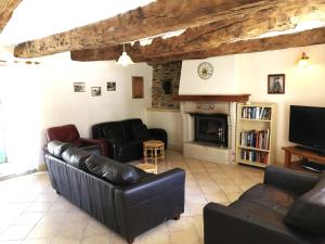 a living room with leather furniture and a fireplace at Clipgites in Pleugriffet