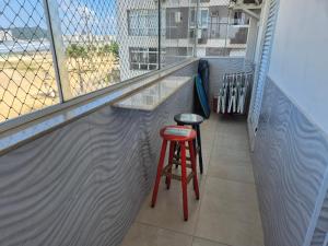 a bar with two stools on a balcony at Verdadeiro pé na areia TOP in Santos +45 photos