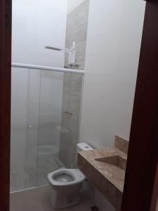 a bathroom with a toilet and a shower and a sink at Área de lazer Cantinho do Fofo in São Carlos