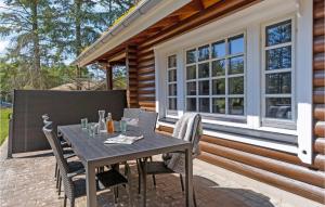 a patio with a table and chairs in front of a house at Holiday Home Blokhus 59 in Blokhus +11 photos