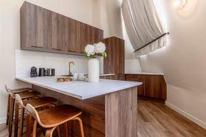 a kitchen with a counter with two chairs and a table at Résidence LeVilliers in Paris