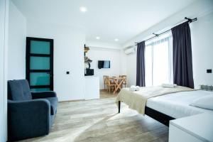 una camera da letto con un letto, una sedia e una finestra di Level Up Hotel & Restaurant a Kobuleti