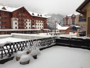 a balcony covered in snow with buildings in the background at T3 avec terrasse plein sud au pied des télécabines in Briançon