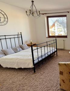 a bedroom with two beds and a window and a chandelier at Villa Menhardi in Nová Lesná