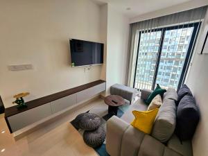 a living room with a couch and a flat screen tv at T- Plus Apartment - Căn hộ 2 PN view hồ bơi in Thôn Văn Dương