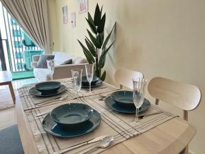 a dining room table with plates and glasses on it at Muji Haus near Sunway City #2Bedroom #Netflix in Subang Jaya
