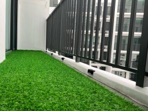 a balcony with green grass in front of a building at Muji Haus near Sunway City #2Bedroom #Netflix in Subang Jaya