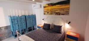 a bedroom with a bed and a painting on the wall at Casa Tabaiba in Parque Holandes