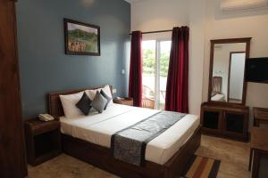 a bedroom with a large bed and a window at Pearl Island Inn in Jaffna