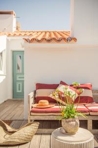 a living room with a bed and a table with a plant at Salty Waters Apartment in Carvalhal +10 photos