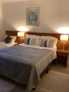 two beds in a bedroom with two lamps on tables at Flesk River 22 in Killarney