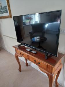 a large flat screen tv sitting on a wooden table at Rusling House in Bristol