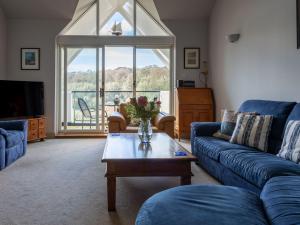 a living room with a blue couch and a coffee table at 17 St Elmo Court in Salcombe