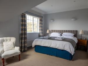 a bedroom with a bed and a chair and a window at 17 St Elmo Court in Salcombe +27 photos