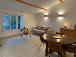 a living room with a table and a couch at Charmante Maisonnette au calme, proche de Lyon in Dagneux