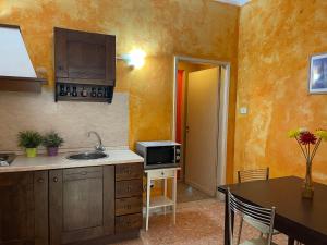 eine Küche mit einer Spüle, einer Mikrowelle und einem Tisch in der Unterkunft Bardi-Ponte Vecchio in Florenz + 48 Fotos