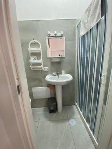 un piccolo bagno con lavandino e doccia di Le 3 Sorelle House a Napoli