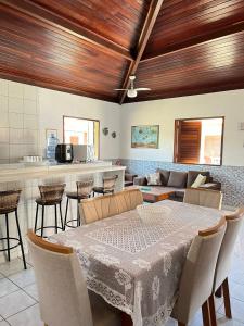 a dining room with a table and a kitchen at Village Miramar in Maragogi