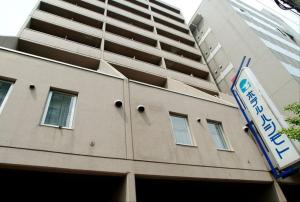 un edificio con un cartel en el costado en Hotel Hashimoto, en Sapporo