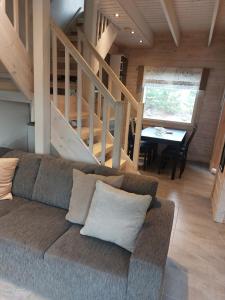 a living room with a couch and a staircase at Rinnelehto in Jämsä