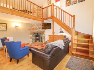 a living room with a couch and a fireplace at Church Barn in Grantham