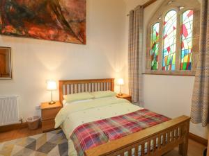 a bedroom with a bed and a stained glass window at Church Barn in Grantham