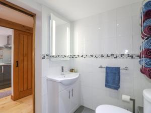 a white bathroom with a sink and a toilet at Church Barn in Grantham +23 photos