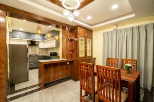 a kitchen with a wooden table and chairs at SID Royale in Gachibowli