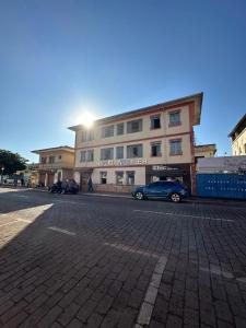 マリアナにあるHotel Mullerの建物の前に車が駐車されている