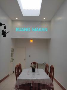 una mesa con sillas y un signo de readsring makan en Aiman's Homestay for Muslim, en Kuching