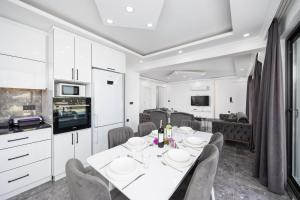 a dining room with a white table and chairs at Villa Grand Yasar 2 in Okçular