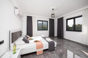 a bedroom with a large white bed and windows at Villa Grand Yasar 2 in Okçular +36 photos