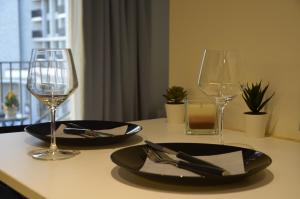 a table with two glasses and a plate and fork and knife at Waterfront Retreat with Garage and Balcony in Belgrade