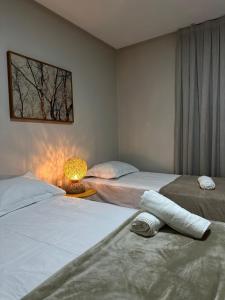 een slaapkamer met twee bedden en een lamp op een tafel bij Charme D'Maria Pousada in Barreirinhas