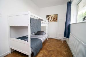 Un dormitorio con dos literas y una ventana. en The Lockett Wonderful Large Bungalow Plympton, Plymouth Free Parking By StayStaycations, en Plymouth
