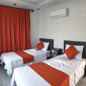 two beds in a room with red curtains at Adrasan Villa Adrasya in Olympos +16 photos