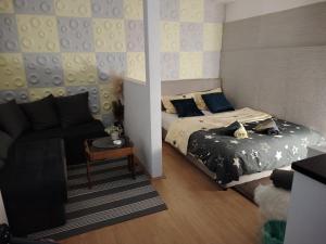 una camera da letto con un letto e un divano di Cozy Max Studio a Jagodina