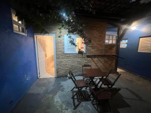 a patio with chairs and a table in front of a building at Nalu Suítes Maresias in Maresias