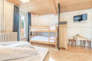 a bedroom with two bunk beds and a desk at Gasthof Bären in Hasliberg