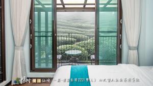 una camera da letto con un letto e un balcone con vista di 璟隆慢活仙境民宿 a Kung-t'ien-ts'un