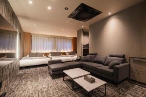 a living room with a couch and a bed at The LOFT INN HAKATA in Fukuoka