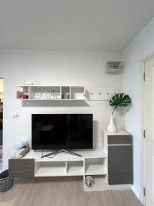 a living room with a large flat screen tv at D condo sign D4 in Chiang Mai