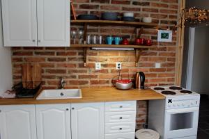 a kitchen with white cabinets and a brick wall at Apartment Polianka in Vysoké Tatry +2 photos