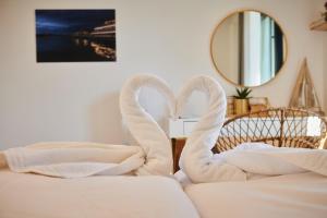 two swans towels sitting on top of a bed at Altstadtliebe Konstanz - harmonischer Luxus in Konstanz